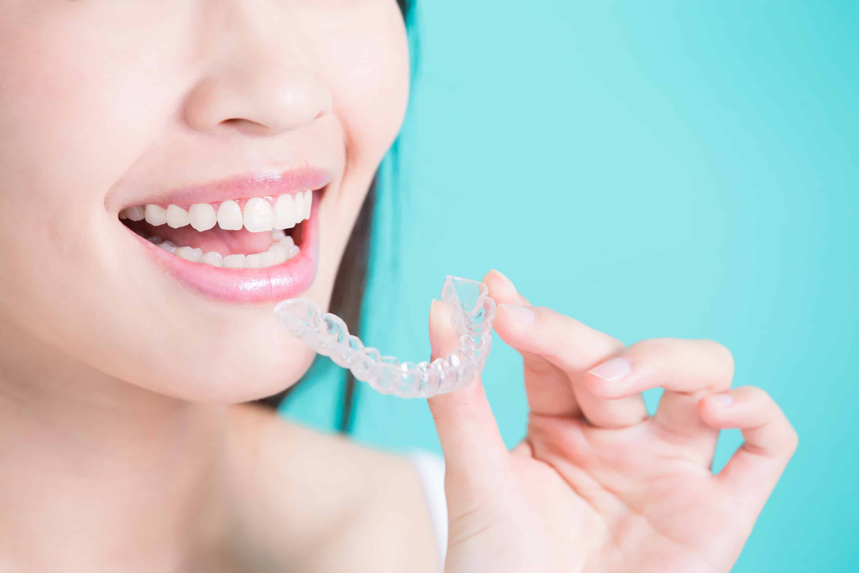 Bệnh nhân cầm khay niềng Invisalign trong suốt